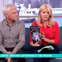ITV's This Morning. Presenters Phil and Holly are on the sofa. Holly is holding a copy of Goodnight Spaceman while talking to astronaut Tim Peake aboard the International Space Station.